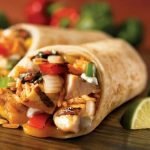 close-up-of-a-savory-chicken-burrito-with-fresh-lime-wedges-showcasing-vibrant-mexican-ingredients